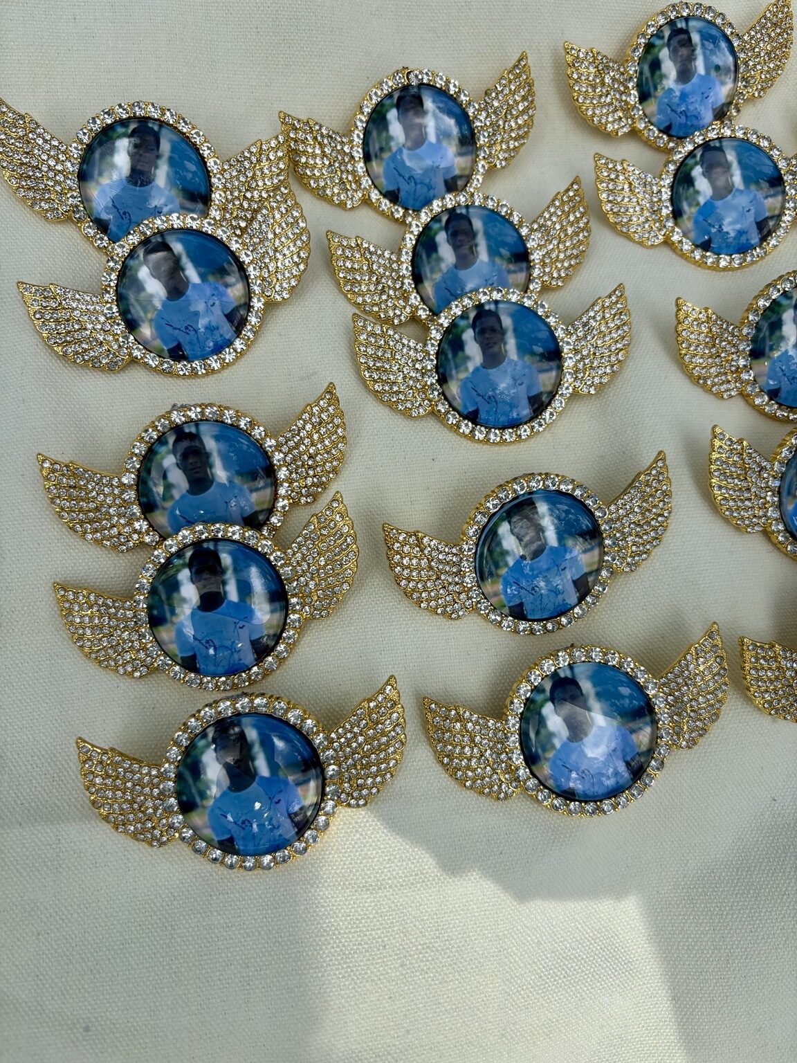 Collection of gold angel-wing memorial pins
